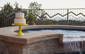 2-tier yellow and white cake next to a jacuzzi