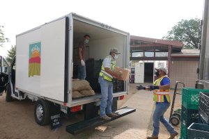 People delivering food from a truck. 