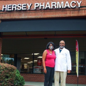 Man and woman standing in front of a pharmacy