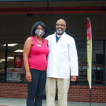 Man and woman standing in front of a pharmacy