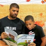 Man and child reading a book.