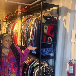 A woman standing in front of a rack of clothing