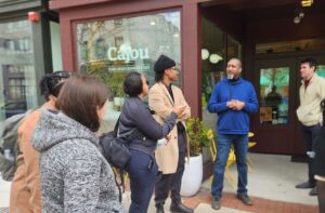 A group of people standing in front of a coffee shop