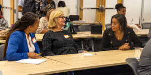Three women sitting at a classroom table